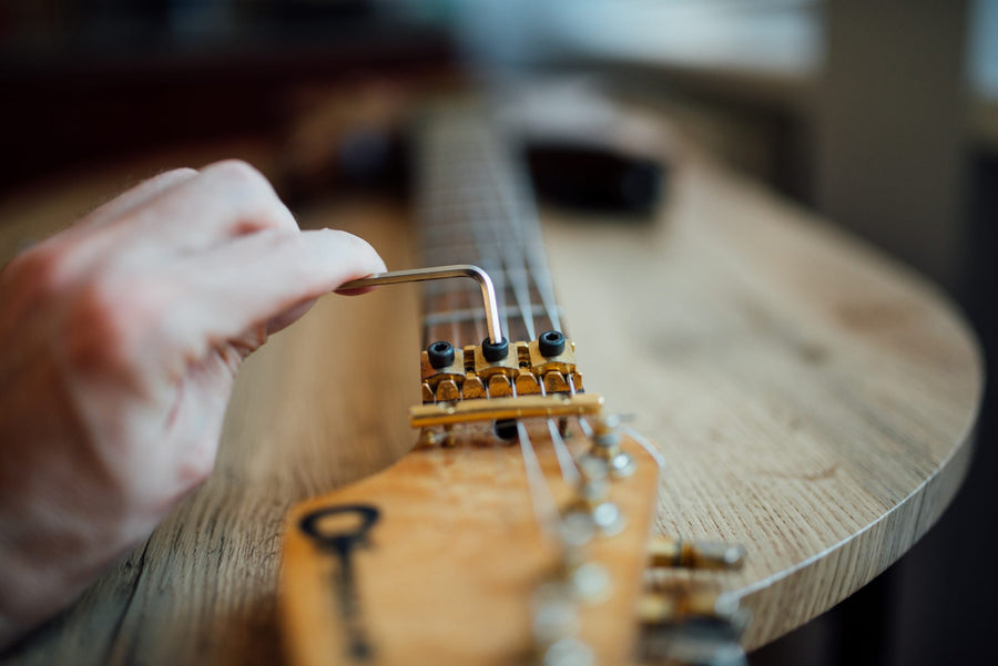 Acoustic vs electric guitar hand tuning a guitar headstock